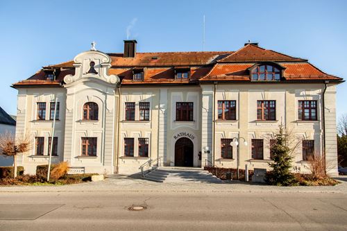 ein großes weißes Gebäude mit einem roten Dach
