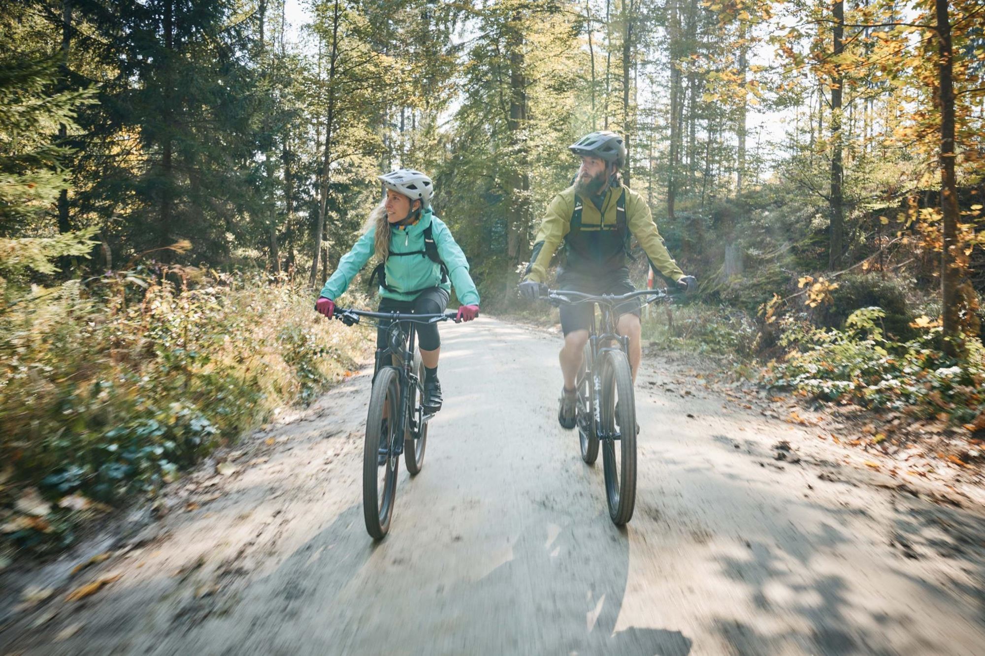 eine Person und eine Person fahren auf einem unbefestigten Weg Fahrrad