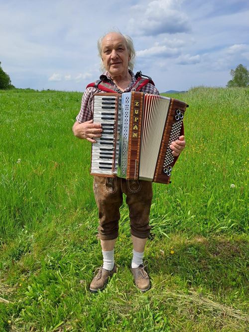 eine Person mit einem Akkordeon auf einem Feld