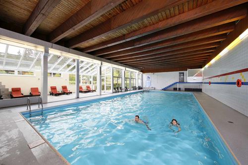 Das Hallenbad im Knaus Campingpark. Neben dem Becken befindet sich ein Ruhebereich mit gemütlichen, gepolsterten Liegen.